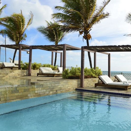 Gazebos postos em frente ao mar com duas espreguiçadeiras