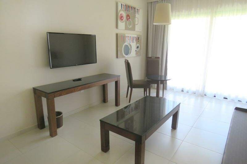 Suíte Tradicional detalhes da entre sala com sofá e televisão