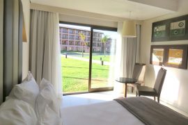 Vista do apartamento com cama de casal e varanda, tudo isso num regime all inclusive ideal para você!
